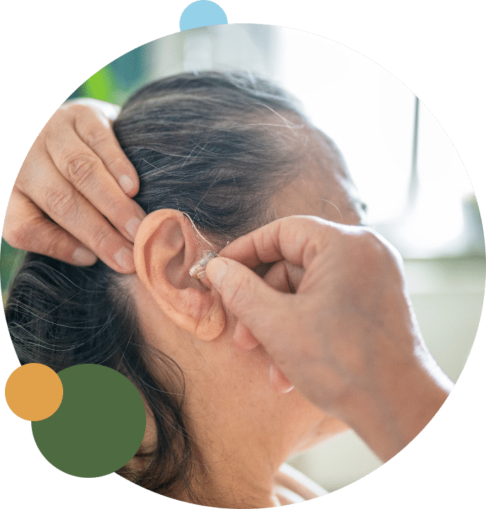 Woman getting a hearing aid from her local audiologist