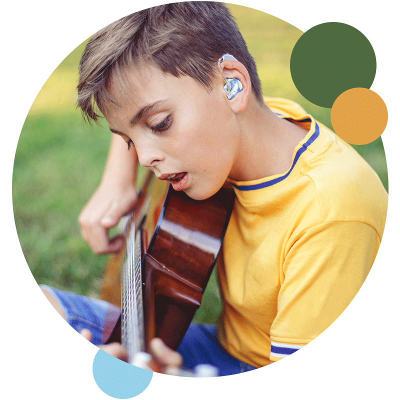 Young boy using hearing protection while playing music